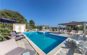 une piscine avec des chaises longues et une piscine dans l'établissement Beautiful Apartment In Liznjan With 1 Bedrooms, Wifi And Outdoor Swimming Pool, à Ližnjan