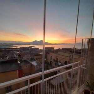 a view of the sunset from the balcony of a building at Suite Estasi in Naples