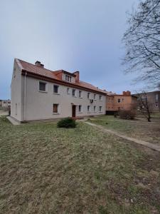 a large white house with a grass yard at 2bedroom apartment in Gulbiu street in Klaipėda