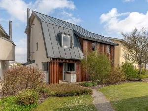 una casa con un tetto di metallo sopra di Cotswolds Lakehouse, with hot tub & spa access, Lower Mill Estate a Somerford Keynes
