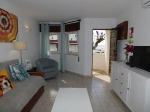 a living room with a couch and a tv at Luz Beach Center in Luz
