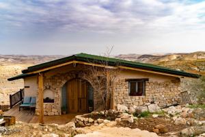 a small stone house with a green roof at Tambourine Guest house טמבורין גסט האוס in Tekoa