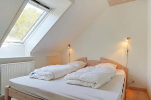 2 Kissen auf einem Bett in einem Zimmer mit Fenster in der Unterkunft Egebjerggaard Bed & Breakfast in Sig