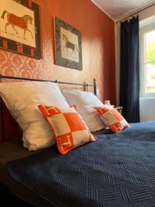 a bedroom with a bed with orange walls and pillows at CASA LINDNER Villa Rustico Ferienhaus 400m zum Gardasee 13Schlafplätze in Toscolano Maderno