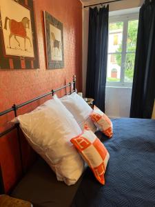 1 dormitorio con cama con almohadas y ventana en CASA LINDNER Villa Rustico Ferienhaus 400m zum Gardasee 13Schlafplätze en Toscolano Maderno