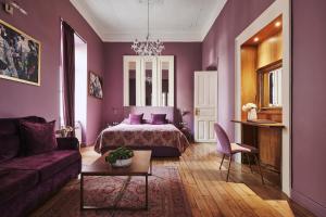 Dormitorio púrpura con cama y sofá en Bohemian Suites Athens, en Atenas