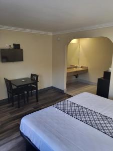 北山的住宿－Budget Inn，客房设有两张床、一张桌子和一张书桌。