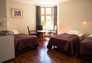 a room with two beds and a table and a window at Cochs Pensjonat in Oslo +37 photos