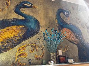 a painting of two birds on a wall at CASA LINDNER Villa Rustico Ferienhaus 400m zum Gardasee 13Schlafplätze in Toscolano Maderno