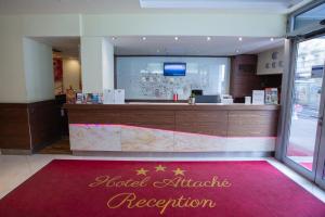 a restaurant with a reception desk and a red rug at Hotel Attaché contactless in Vienna