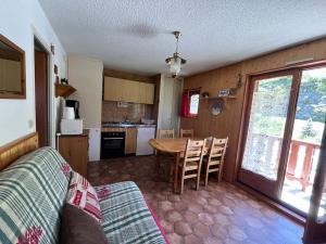 a living room with a table and a kitchen at Appartement ensoleillé Lanslevillard station Val Cenis Vanoise in Lanslevillard +24 photos