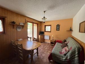 a living room with a table and a couch at Appartement ensoleillé Lanslevillard station Val Cenis Vanoise in Lanslevillard