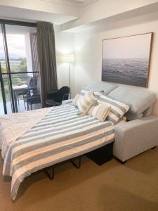a bedroom with a large bed and a chair at Cozy Cool Getaway in Townsville