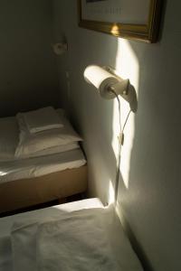 a bedroom with a bed and a lamp on the wall at Cochs Pensjonat in Oslo