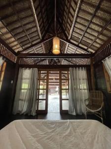 a bedroom with a bed and a ceiling with a window at Marahuyo - Off-grid, beachfront, private cabin in Taytay