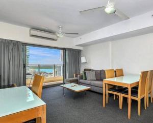 a living room with a couch and a table at One bed Harbour and city views apartment in Darwin
