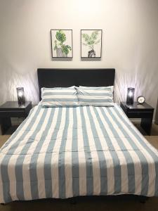 a bedroom with a striped bed with two night stands at Cozy Cool Getaway in Townsville