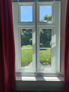 an open window with a view of a yard at Lower Winsford Apartments & Rooms in Bideford