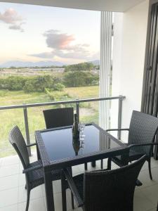einen Tisch und Stühle auf einem Balkon mit Blick auf ein Feld in der Unterkunft Cozy Cool Getaway in Townsville