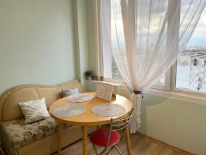 a small table and chair in a room with a window at Airport Apartment in Sofia