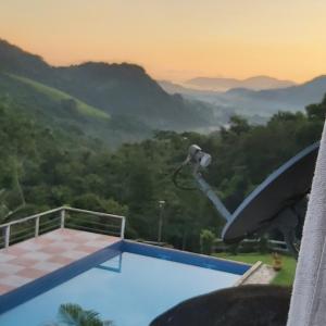 uitzicht op een zwembad met bergen op de achtergrond bij Pousada La Dolce Vita Paraty in Paraty