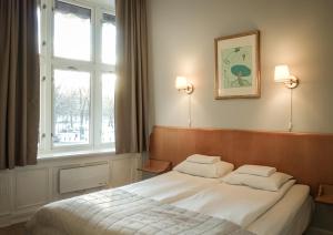 a bedroom with a large white bed with a window at Cochs Pensjonat in Oslo