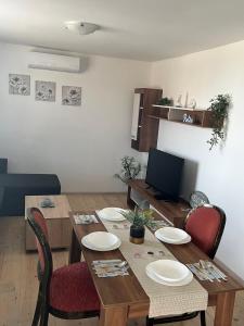 comedor con mesa, sillas y TV en Еко Къщи Къмпинг Созопол Еко en Sozopol