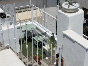 a balcony with a table and a plant on the stairs at Q40 Ostuni in Ostuni