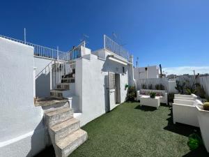 a white house with stairs and green grass at Q40 Ostuni in Ostuni