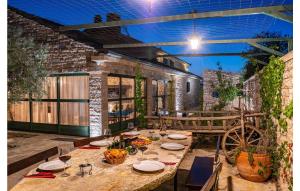 a table with plates and wine glasses on a patio at Stunning Home In Lisicic With 3 Bedrooms, Wifi And Outdoor Swimming Pool in Lisičići