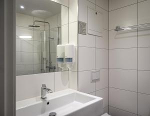 a white bathroom with a sink and a mirror at Cochs Pensjonat in Oslo