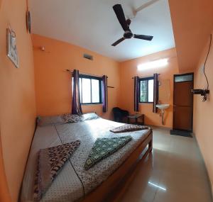 1 dormitorio con 1 cama y ventilador de techo en Kshanbhar Vishranti Home Stay en Malvan