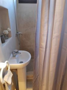 łazienka z umywalką i zasłoną prysznicową w obiekcie Les Domaines de Marrakech w Marakeszu