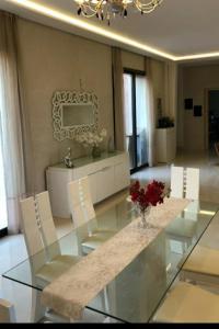 una sala da pranzo con tavolo in vetro e sedie bianche di Les Domaines de Marrakech a Marrakech