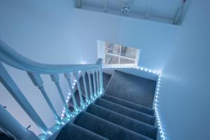a stairway with blue lights in a house at Luxe Maisonette- Parking, 4K TVs, LEDs, Local Snacks and more! in Bath