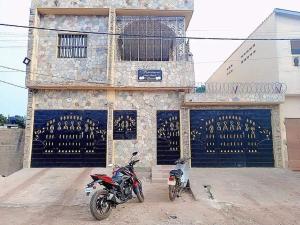 une moto garée devant un bâtiment dans l'établissement Résidence aux deux cocos, à Lomé