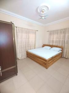 - une chambre avec un lit et un ventilateur de plafond dans l'établissement Résidence aux deux cocos, à Lomé