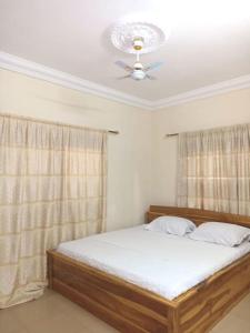 Schlafzimmer mit einem Bett und einem Deckenventilator in der Unterkunft Résidence aux deux cocos in Lomé