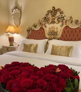 Una cama con un montón de rosas rojas. en Hotel Empire Albania en Durrës