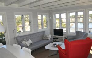 MebøにあるGorgeous Home In Flekkery With Wifiのリビングルーム(ソファ、テーブル付)