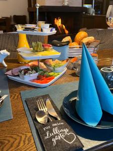a table topped with plates of food with blue napkins at Health and Spa by Doro im Hotel am Schwanenweiher in Bad Bertrich