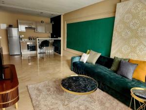 - un salon avec un canapé vert et une table dans l'établissement Studio lumineux avec piscine/Gare casa oasis, à Casablanca