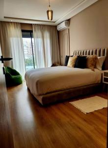 1 dormitorio con cama y ventana grande en Studio lumineux avec piscine/Gare casa oasis en Casablanca