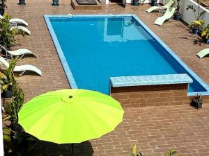a yellow umbrella sitting next to a swimming pool at Studio lumineux avec piscine/Gare casa oasis in Casablanca