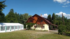 a house with a greenhouse in a yard at Vila Roseta in Cărbunari