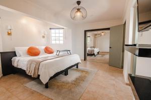 Villa Fontana 1 & 2 في شاطئ بالم إيغل: غرفة نوم مع سرير ووسائد برتقالية عليه