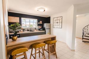 a kitchen with a wooden counter and stools at Villa Fontana 1 & 2 in Palm-Eagle Beach