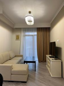 ein Wohnzimmer mit einem Sofa und einem TV in der Unterkunft Alvina apartment hotel in Zaghkadsor