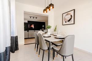 Villa Fontana 1 & 2 في شاطئ بالم إيغل: غرفة طعام مع طاولة بيضاء وكراسي