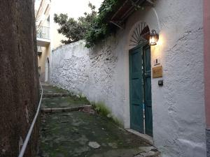 una porta verde sul lato di un edificio bianco di Dimora di Enea - Gaeta Medievale a Gaeta
